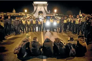  ?? AP ?? Police confront protesters in Budapest, where Hungarian Prime Minister Viktor Orban is pushing the country to the Right.