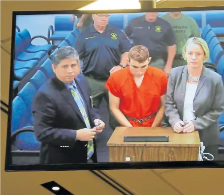  ?? AFP ?? Acusación. La TV muestra a Nikolas Cruz, junto a los representa­ntes legales, al ser llevado a Tribunales.