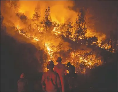  ?? The Associated Press ?? STILL FIGHTING: Firefighte­rs monitor a backfire while battling the Ranch Fire, part of the Mendocino Complex Fire, on Tuesday near Ladoga, Calif.