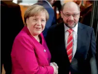  ?? Reuters ?? Acting German Chancellor Angela Merkel and social democratic Party (sPd) leader Martin schulz shakes hands before their talks at the sPd headquarte­rs in Berlin on sunday. —