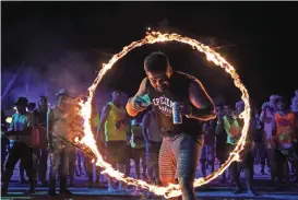  ??  ?? This picture shows a reveler walking through a hoop of fire during a Full Moon Party on the southern island of Ko Phangan. — AFP photos