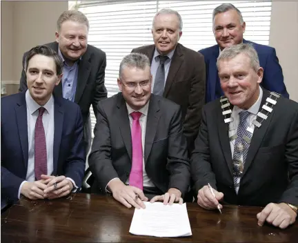  ??  ?? Wicklow County Council Chief Executive Frank Curran signs the contract with Minister Simon Harris; Sean Sheehy, Director of the Irish Assemblies of God (IAOG) which was selling Carraig Eden; PJ Booth, Consultant to the IAOG board; Cllr Gerry Nolan,...