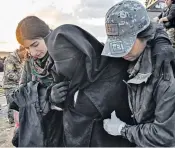  ??  ?? Rescue: Kurdish soldiers help an injured woman at a gathering point for civilians fleeing Isil territory, near Baghuz, Syria