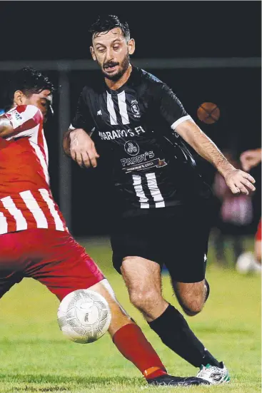  ?? Picture: STEWART MCLEAN ?? CHASING A THREE-PEAT: Douglas United’s Adriano Gualtieri gets by Innisfail’s Jayden Zecchinati in FFA Cup action. Rain has delayed Douglas’s quest for a third straight title,