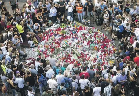  ?? Quique Garcia European Pressphoto Agency ?? TRIBUTES for victims are piled up on Barcelona’s Las Ramblas. The dead included a mother of two from Belgium and two Italian men.