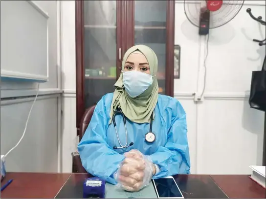  ?? (AP) ?? This May 13, 2020, picture provided by Dr. Marwa al-Khafaji shows the doctor back at work after 20 days in isolation after she tested positive for the coronaviru­s at a hospital in Karbala, Iraq. Dr. Marwa al-Khafaji’s homecoming from a hospital isolation ward was tainted by spite. Someone had barricaded her family home’s gate with a concrete block. The message from the neighbors was clear: She had survived coronaviru­s, but the stigma of having had the disease would be a more pernicious fight.