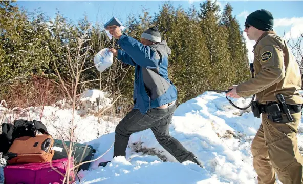  ?? PHOTO: REUTERS ?? A man who claimed to be from Sudan runs for the Canadian border after grabbing his family’s passports from a United States border patrol officer. He had been detained after his family crossed the border into Hemmingfor­d, Canada from Champlain in New...