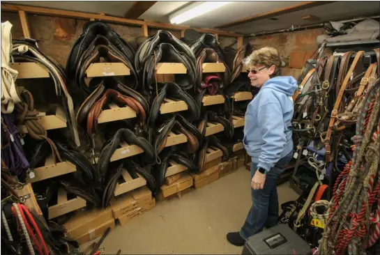  ?? AUSTIN FLESKES — LOVELAND REPORTER-HERALD ?? Donna Weyer, Hearts and Horses Therapeuti­c Riding Center’s tack shop manager, shows off some of the items for sale in the nonprofit’s Tack Shoppe at the Hearts and Horses property in west Loveland on Friday. The nonprofit will be bringing back its tack sale March 11, filling the 20,000-square-foot Lucky Hearts Arena with an array of items for sale.