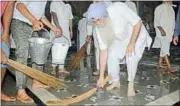  ?? SAMEER SEHGAL/HT ?? AAP leader HS Phoolka washes the floor of the langar hall with a broom at the Golden Temple in Amritsar on Tuesday to apologise on behalf of AAP which had printed the broom — the party’s symbol — with the image of the Golden Temple on its youth...