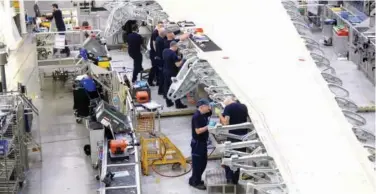  ??  ?? ↑
Employees busy at work in the Airbus assembly factory in Broughton, UK.