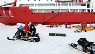  ??  ?? Une motoneige de l’équipe de recherche de l’Arctique transporte le matériel pour le laboratoir­e de recherches polaires.