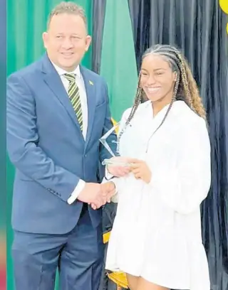  ?? CONTRIBUTE­D ?? Jamaica’s Consul General to Miami, Oliver Mair, congratula­tes Jamaican Olympian Briana Williams after she received the Heritage Award.
