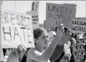  ?? ASSOCIATED PRESS ?? A WOMAN HOLDS UP A SIGN Friday. at a rally in San Francisco on