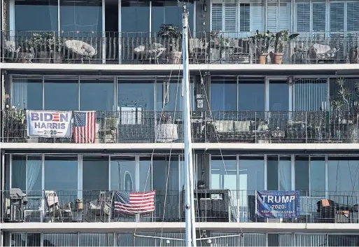  ?? ASHLEY LANDIS THE ASSOCIATED PRESS ?? UPSTAIRS, DOWNSTAIRS Rival Biden and Trump signs are displayed on balconies in Long Beach, Calif., a day before voters deliver their final verdict on the president.