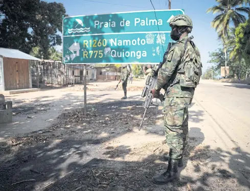  ?? AFP ?? A Rwandan soldier stands in front of a road sign near Palma, Cabo Delgado, Mozambique on Sept 22.