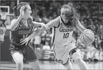  ?? JESSICA HILL/AP PHOTO ?? UConn’s Nika Muhl (10) drives around Vermont’s Catherine Gilwee (14) during the Huskies’ 95-52 victory over the Catamounts in the opening round of the NCAA tournament on Saturday in Storrs.