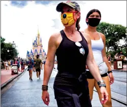  ?? (JOE BURBANK/ORLANDO SENTINEL/TNS) ?? Guests wore masks, as required, to attend the official re-opening day of the Magic Kingdom at Walt Disney World in Lake Buena Vista, Florida, on Saturday, July 11, 2020.