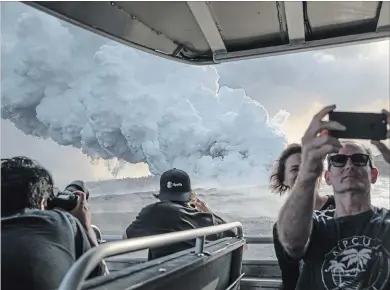  ?? TAMIR KALIFA NYT ?? Passengers take photos of a plume of volcanic gases and steam rising as lava from a Kilauea volcano fissure enters the Pacific.