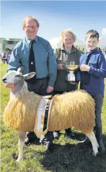  ??  ?? Number one Champion of Champions, the Bluefaced Leicester ewe with proud James, Etta and Matt Drummond