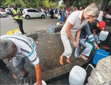  ?? Nic Bothma EPA/Shuttersto­ck ?? CAPE TOWN residents fill up on drinking water from a mountain spring collection point last week. Residents are now limited to 23 gallons of tap water per person each day. But only 39% are meeting the target.