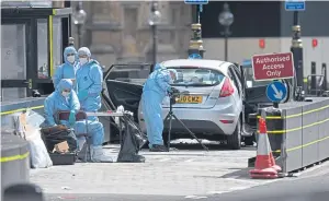  ??  ?? Forensics officers check out the car that crashed into a secutiy barrier last week