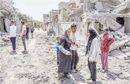  ?? Agence France-presse ?? People search through the rubble of a collapsed building in the Maghazi camp on Monday.