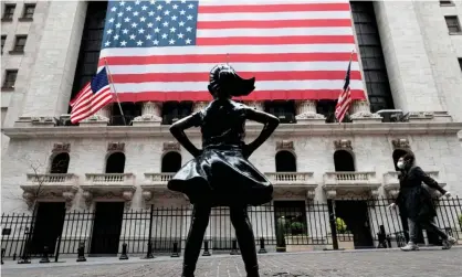  ?? Photograph: AFP/Getty ?? The Fearless Girl sculpture outside the New York stock exchange. The Dow Jones rose at lunchtime despite pessimisti­c forecasts about the US economy.