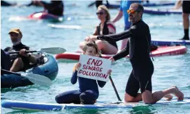  ?? Brighton on Saturday. Photograph: Gareth Fuller/PA ?? A young paddle boarder holds up a placard as Surfers Against Sewage stage a protest in