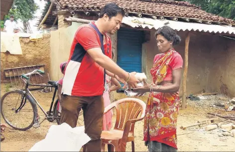  ?? HT PHOTO ?? Mangesh Jha hands over sanitary napkins to a woman at Jonha village in Ranchi.