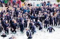  ??  ?? Beim Triathlon stürzen sich sportliche Teilnehmer in die Bucht von Poreč