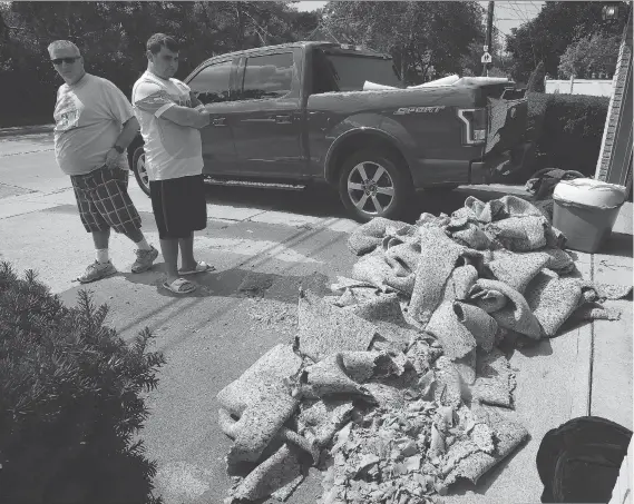  ?? NICK BRANCACCIO ?? Homeowner Kevin Delisle, left, and his nephew Lee Tracey prepare to take a load of carpet to the city transfer station on Wednesday.