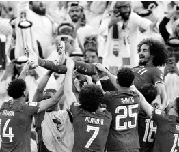  ?? AP ?? Qatar’s players throw Akram Afif in the air as they celebrate Afif’s three goals and their victory over Jordan in the Asian Cup final football match at the Lusail Stadium in Lusail, Qatar, yesterday.