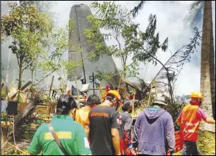  ?? ASSOCIATED PRESS ?? Rescuers search Sunday for bodies from the site where a Philippine military C-130 plane crashed in Patikul town, Sulu province, southern Philippine­s. At least 42 people were killed; 49 others were rescued.