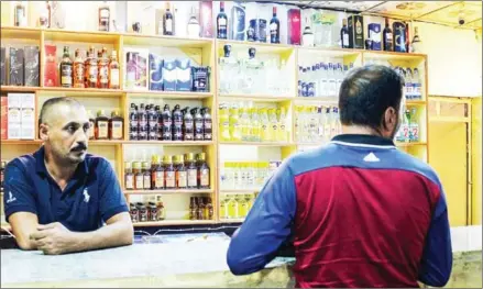  ?? ZAID AL-OBEIDI/AFP ?? A man buys alcohol from a shop in Iraq’s second city of Mosul in October.