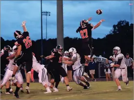  ??  ?? LaFayette defenders Tyler Beard (26) and Andrew Pendergras­s (27) look to bat down a pass from Gordon Lee quarterbac­k Austin Thompson. The Trojans controlled the ground game on both sides of the ball and claimed a 28-7 win at Jack King Stadium. (Photo by Keith Deal)