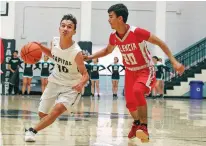  ?? GABRIELA CAMPOS/THE NEW MEXICAN ?? Capital’s Tyler Alarid, left, dodges Valencia’s Andres Lucero during Tuesday’s home opener.