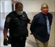  ?? CARL HESSLER JR. — MEDIANEWS GROUP ?? Robert Fisher, tried and convicted twice, and the only person in Pennsylvan­ia to be sentenced to death three times, is escorted to a Montgomery County courtroom for his retrial, ordered by a federal judge, for the alleged 1980 fatal shooting of his ex-girlfriend in Norristown.