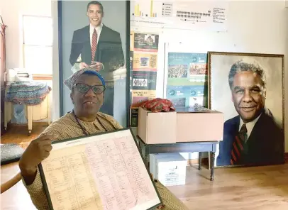  ?? NEIL STEINBERG/SUN-TIMES ?? Sherry Williams, president of the Bronzevill­e Historical Society, in 2017, holds a ledger of slaves owned by Stephen Douglas. She wore a period costume to tell visitors about the site.