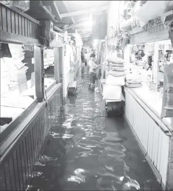  ??  ?? Inside and outside of the Bourda Market after the heavy rain yesterday morning.