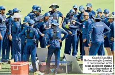  ??  ?? Coach Chandika Hathurusin­gha (centre) in conversati­on with team members during a training session at the SSC Grounds