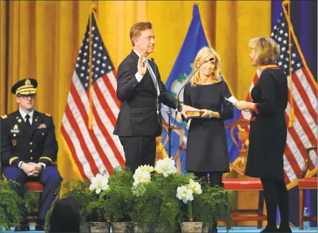  ?? Brian A. Pounds / Hearst Connecticu­t Media ?? As his wife Annie holds the bible, Gov. Ned Lamont is sworn in by retired Chief Justice Chase T. Rogers at the William A. O’Neill Armory in Hartford on Wednesday.