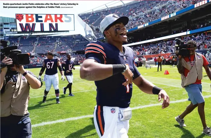  ?? DAVID BANKS/AP ?? Rookie quarterbac­k Justin Fields celebrates after the Bears’ victory Saturday in their preseason opener against the Dolphins at Soldier Field.