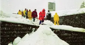  ?? Fotos (2): Ralf Lienert ?? Winter 1999: Der Alpenraum versinkt in den Schneemass­en. Einsatzkrä­fte räumen das Dach des Eisstadion­s in Oberstdorf.