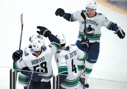  ?? AP PHOTO ?? Vancouver Canucks defenceman Troy Stecher, top right, joins his teammates to celebrate a goal by centre Bo Horvat during the third period of Thursday’s game against the Boston Bruins.