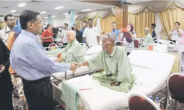  ??  ?? Dr Subramania­m (left) visits some of the patients evacuated after a small fire at Segamat Hospital. — Bernama photo