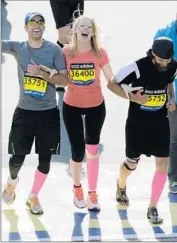  ?? Charles Krupa
Associated Press ?? ADRIANNE HASLET-DAVIS, center, and her brothers finish the Boston Marathon in 2014.