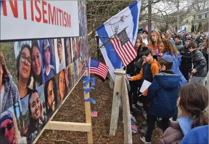  ?? CHRIS CHRISTO — BOSTON HERALD ?? Residents gather to dedicate the rebuilt vandalized hostage memorial wall in front of a home on Homer Street in Newton.