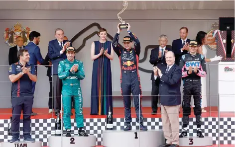  ?? — Reuters ?? Red Bull’s Max Verstappen celebrates on the podium after winning the Monaco GP as Prince Albert II of Monaco with his wife Princess Charlene applaud.