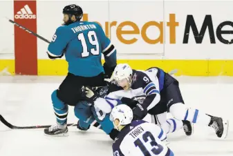  ?? Marcio Jose Sanchez / Associated Press ?? The Sharks’ Mikkel Boedker and Jets’ Andrew Copp (9) fall into center Joe Thornton, who suffered a knee injury in the collision. Thornton could be sidelined for six weeks or more.
