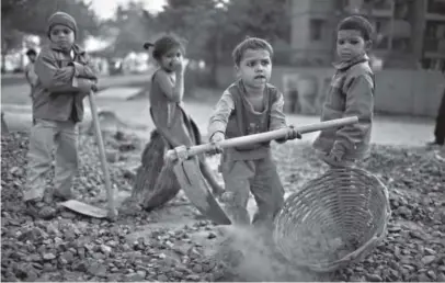  ??  ?? Indian children work close to where their parents are at a constructi­on project in January 2010 in New Delhi. The children receivemon­ey for bread and milk and are provided dinner by the contractor. Getty Images file photo